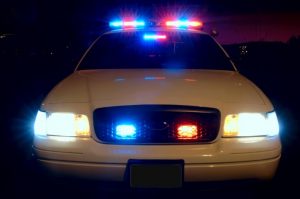 White ford police car with lights lit up at night